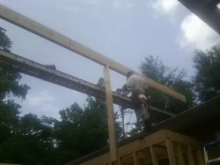 Carpenter setting a ridge beam over a new addition frame — Ice Dam Removal by Roofing Brothers in Staunton