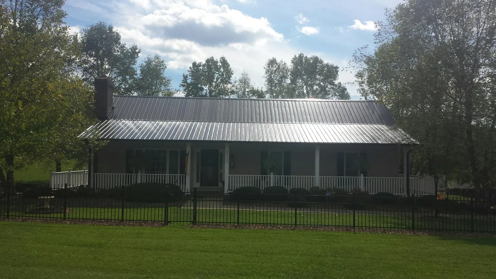 Gray metal roof on a brick ranch with a full width front porch — Gutter Guard Installation work by our crew in Staunton