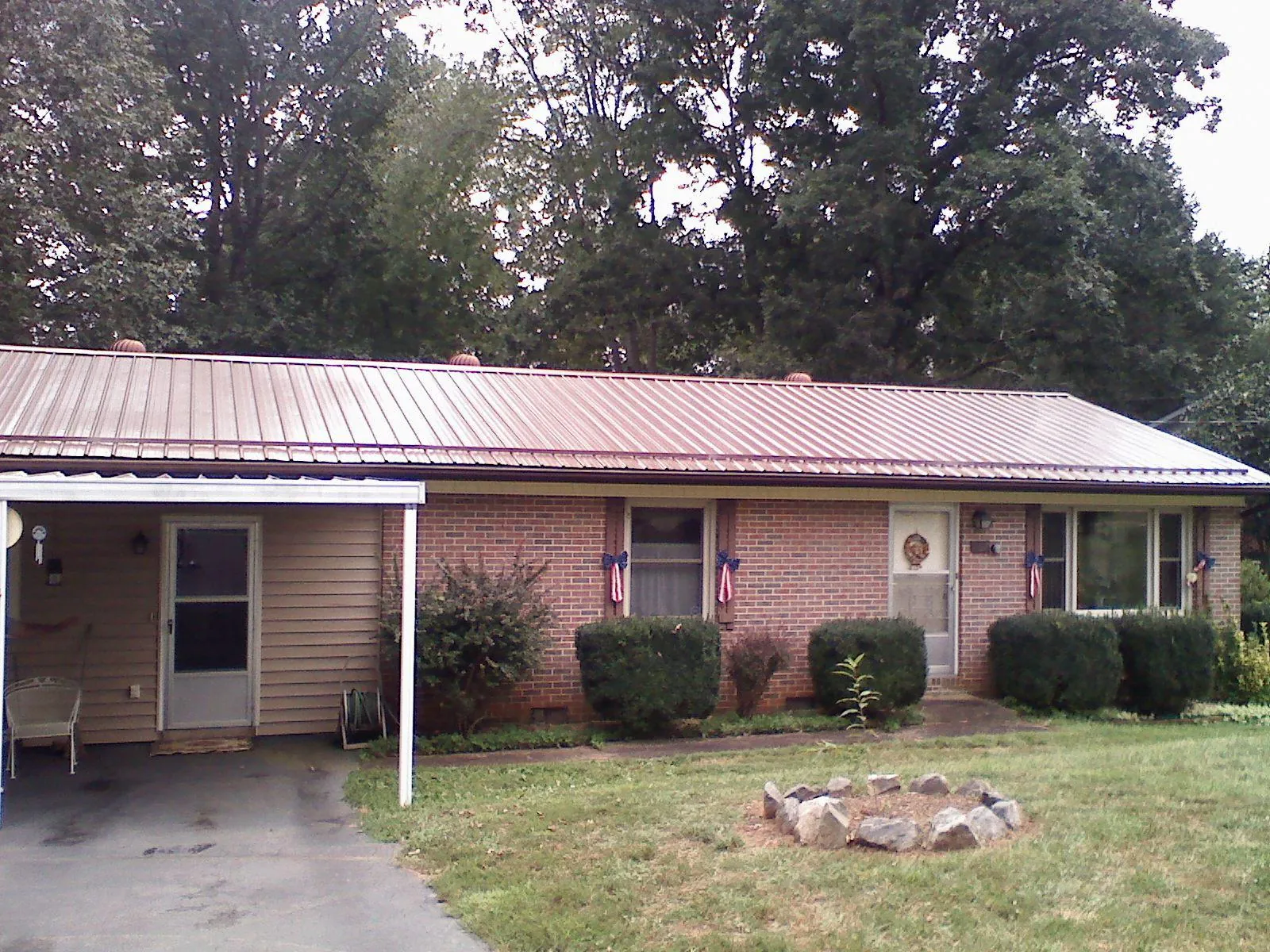 Bronze metal roof and carport on a brick ranch home — Roof Repair work by our crew in Staunton